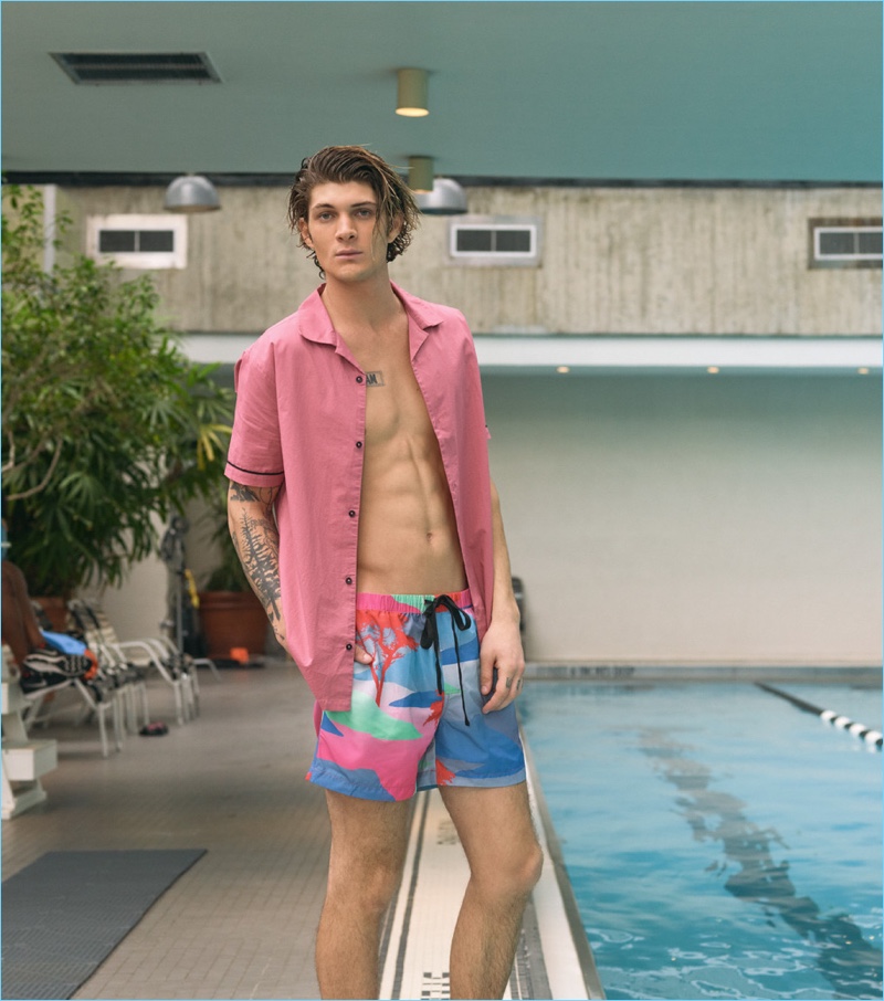 Ready for summer, Jake Lahrman wears a RVCA short-sleeve shirt with Double Rainbouu moon safari night swim shorts.