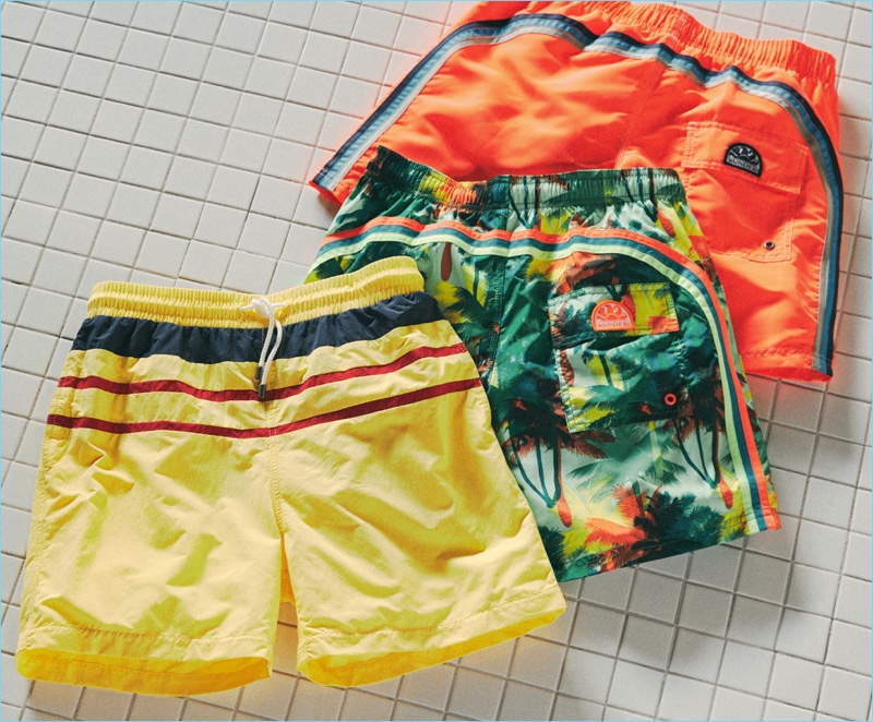 Left to Right: Solid & Striped yellow trunks with stripes, SUNDEK stretch waist long board shorts, SUNDEK long fixed waist board shorts.