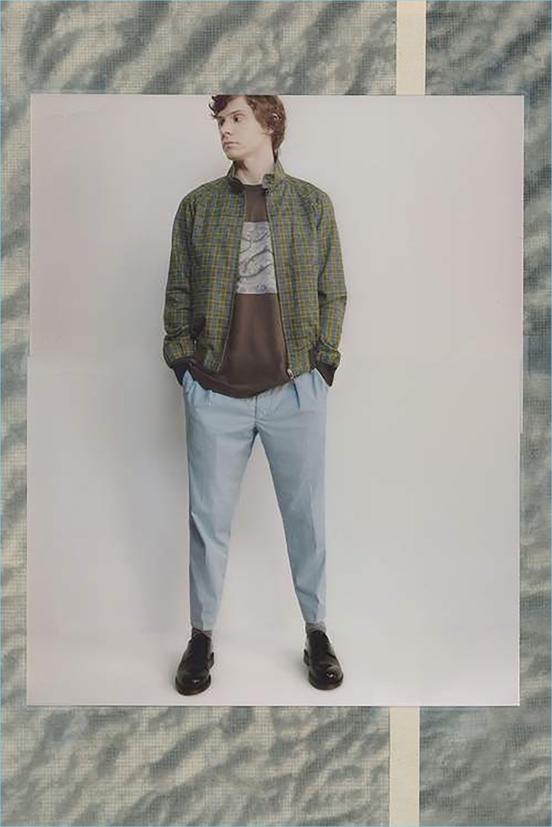 Playing it casual, Evan Peters wears an Acne Studios t-shirt and AMI derby shoes. He also sports a Prada blouson jacket and trousers.