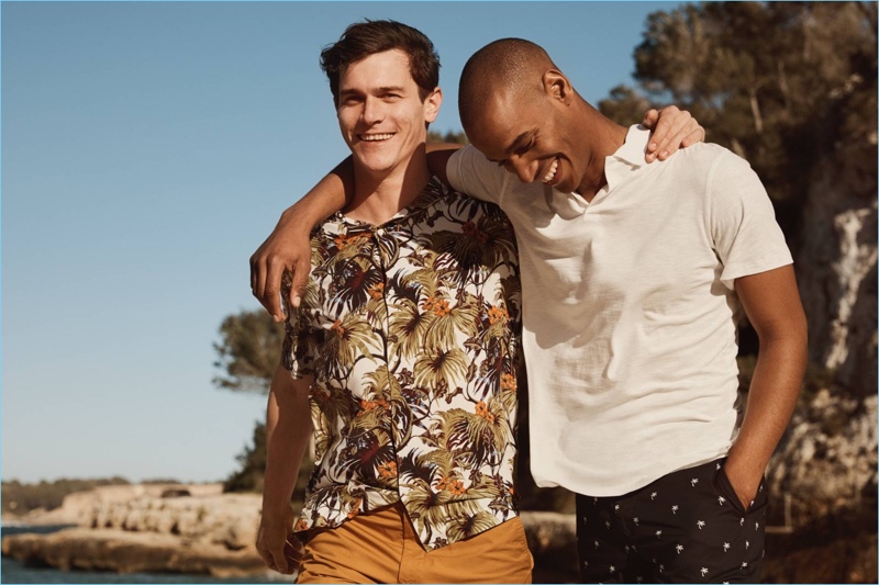 Left to Right: Vincent LaCrocq wears a tropical print shirt with chino shorts by H&M. Sacha M'Baye sports a white H&M polo shirt with palm tree print chino shorts.