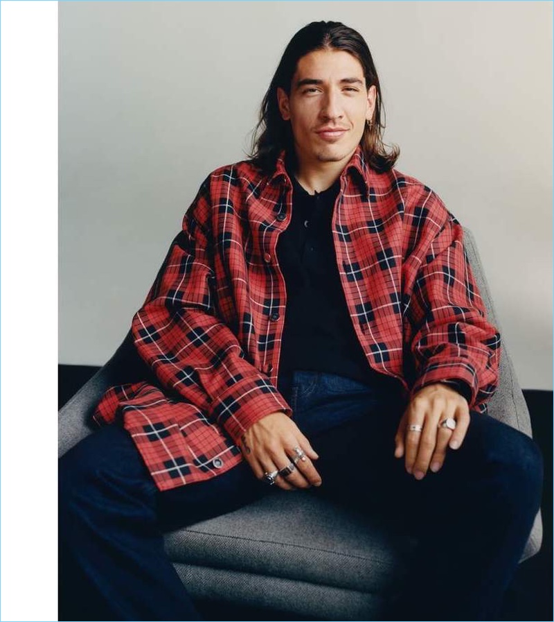 Posing for a relaxed image, Héctor Bellerín wears an oversized Raf Simons check denim shirt and polo with Berluti jeans.