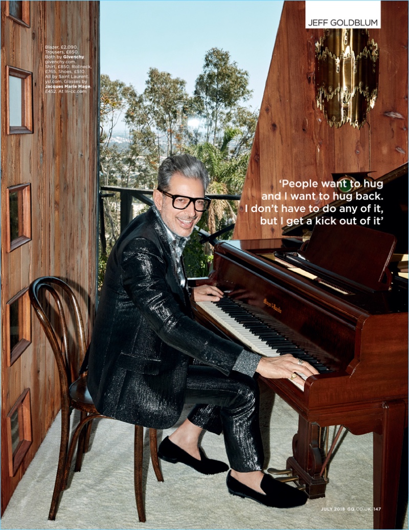 Playing the piano, Jeff Goldblum wears a Givenchy suit with a shirt, turtleneck, and shoes by Saint Laurent. Goldblum's glasses are Jacques Marie Mage.