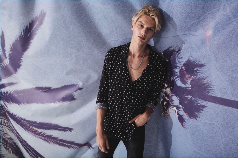Connecting with Ksubi for summer, Jimmy Freeman wears an all-over print black shirt.