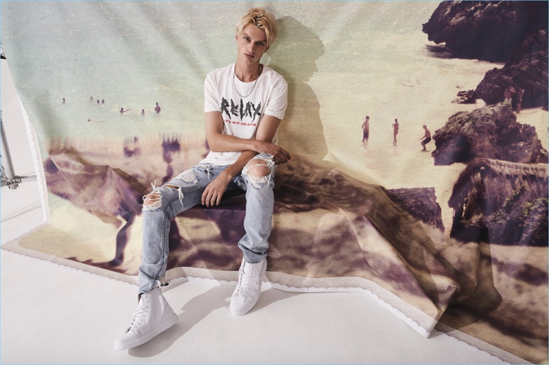 Model Jimmy Freeman rocks ripped denim jeans and a graphic tee by Ksubi.