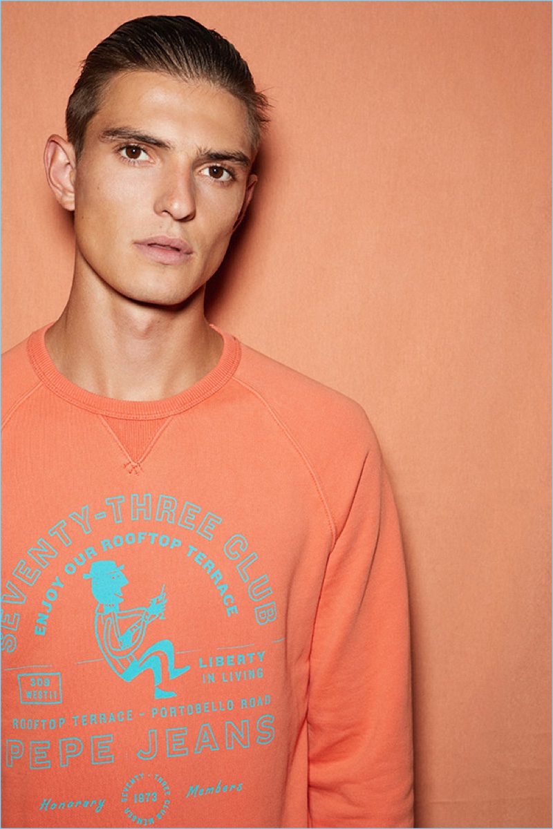 Model Guerrino Santulliana wears an orange pullover from Pepe Jeans' pre-fall 2018 lineup.