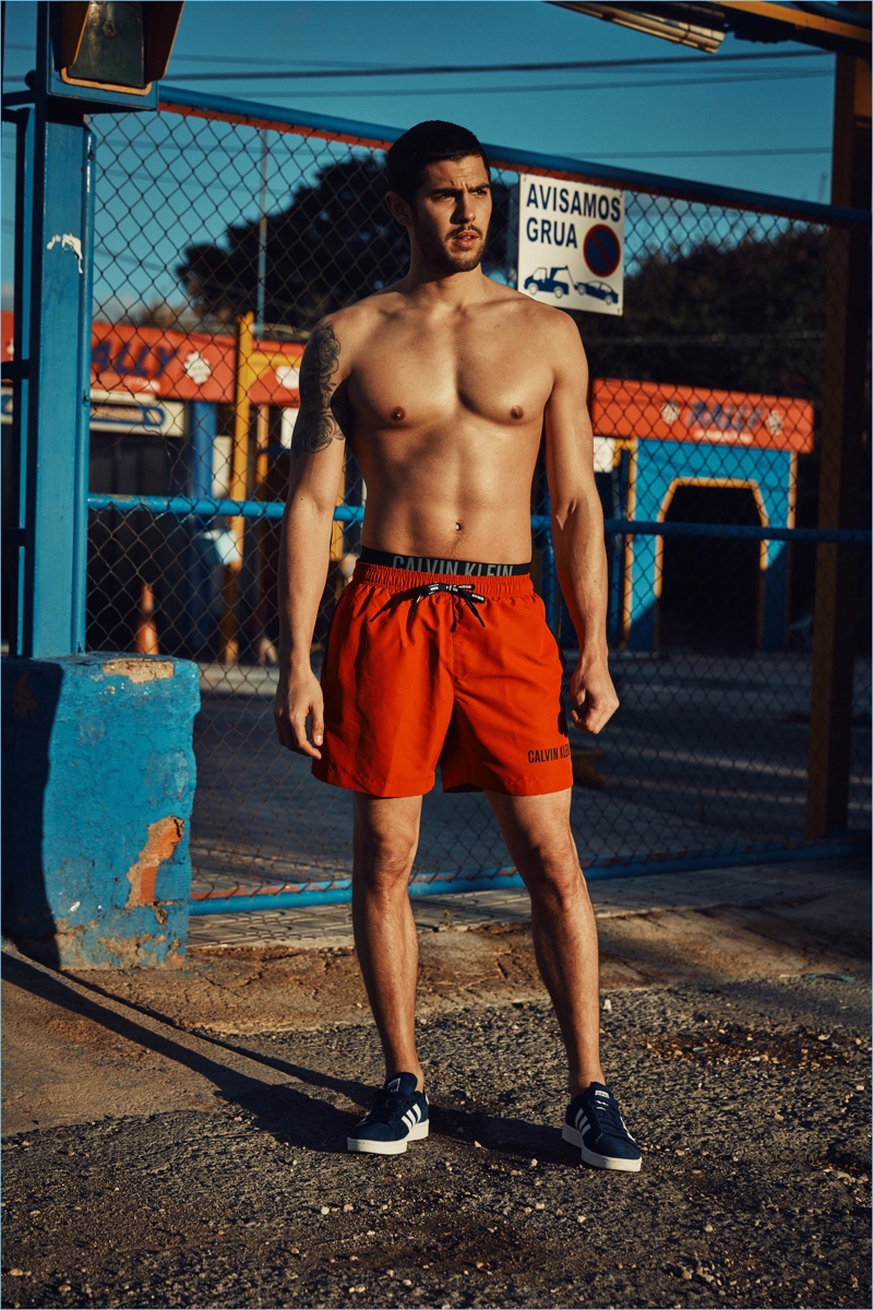 Standing out in red swim shorts, René Grincourt wears Calvin Klein.