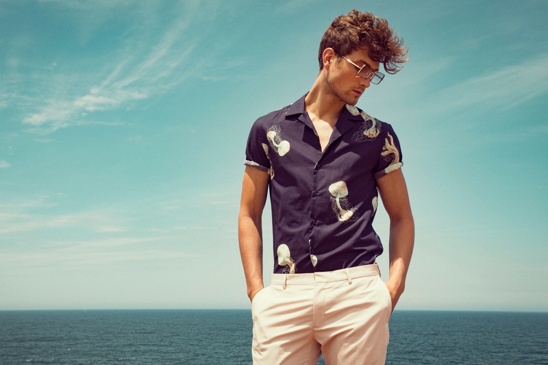 A summer vision, Saxon sports a Zara camp-collar shirt with trousers and TVR OPT glasses.