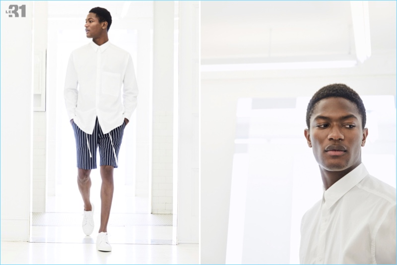 Model Hamid Onifade sports a shirt and nautical stripe Bermuda shorts by LE 31. He also wears Simons sneakers in white.