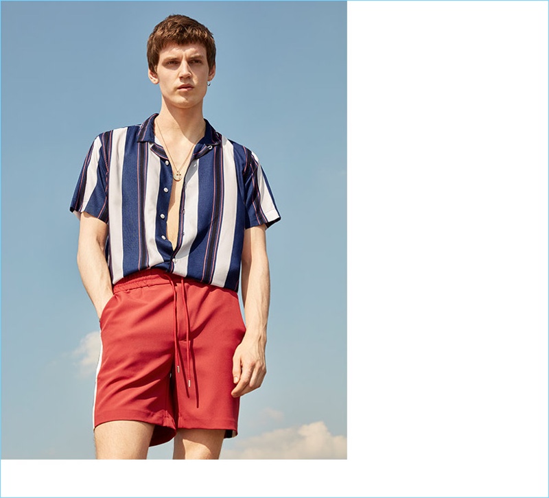 A summer vision, Theo Neilson dons a striped short-sleeve shirt from Topman.
