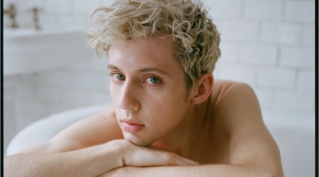 Troye Sivan Covers Out Magazine, Talks Fashion Posing in a bathtub, Troye Sivan rests on a Stella McCartney sweater.