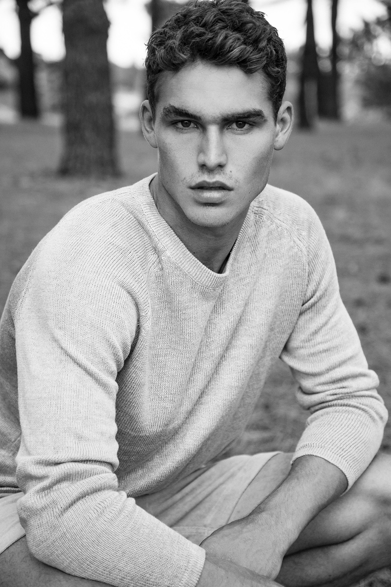 Appearing in a black and white photo, Brayden wears a sweater and shorts from Venroy.
