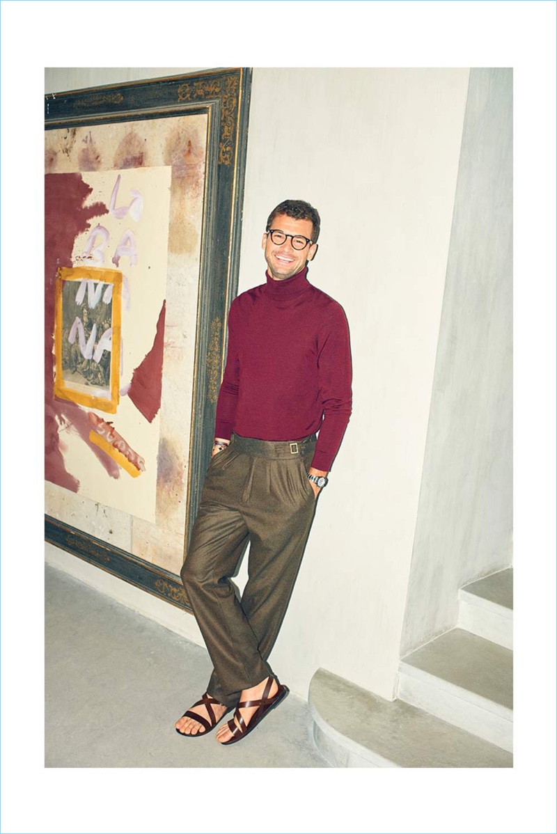 A chic vision, Grigor Dimitrov dons a Boglioli turtleneck sweater, Rubinacci trousers, and Ray-Ban glasses.