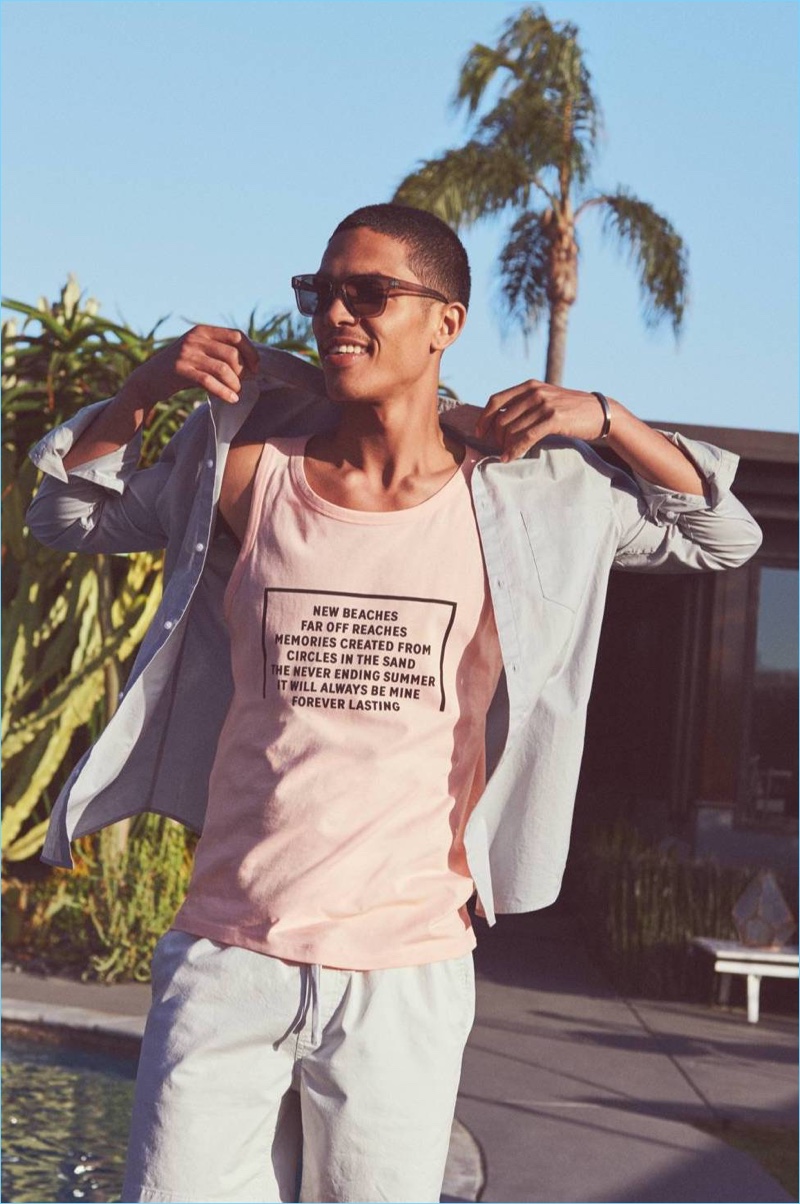 Going casual, Geron McKinley wears a coral H&M tank, cotton shirt and shorts in grey.