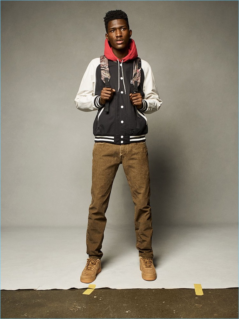 Anarcius Jean goes sporty in a Levi's varsity jacket and denim for fall.