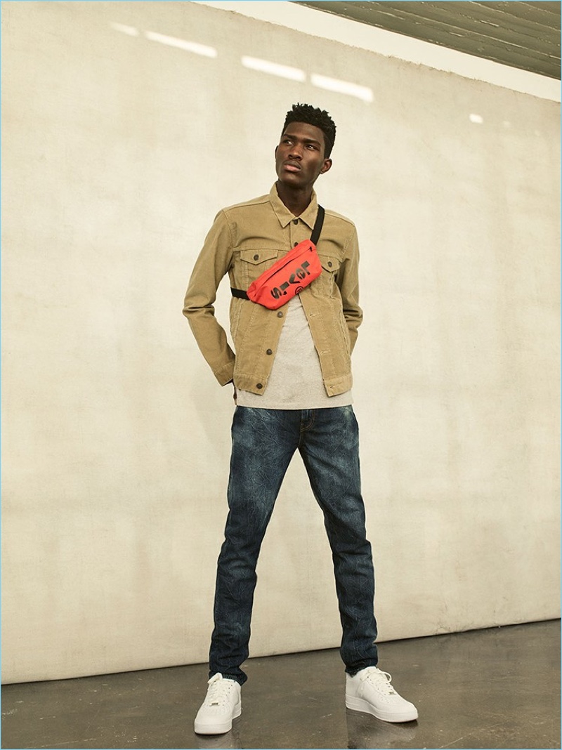 Sporting a Levi's belt bag, Anarcius Jean also wears a corduroy jacket and jeans from the label.