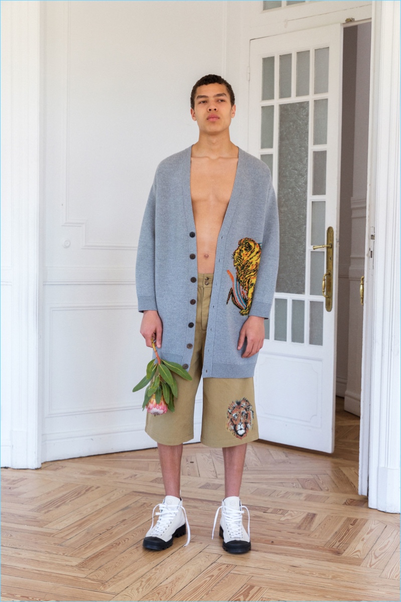 Louis Griffiths dons an oversized Loewe cardigan and shorts adorned with a lion.