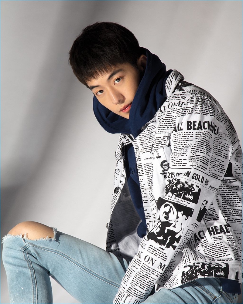 Nam Joo Hyuk embraces an urban cool in a newspaper print jacket, hoodie, and light wash denim jeans from Penshoppe.