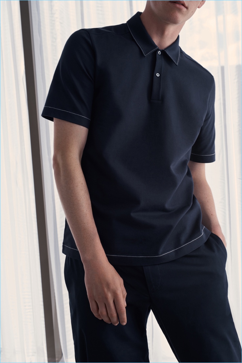 Model Anders Hayward wears a COS stitch-detail polo shirt in navy.