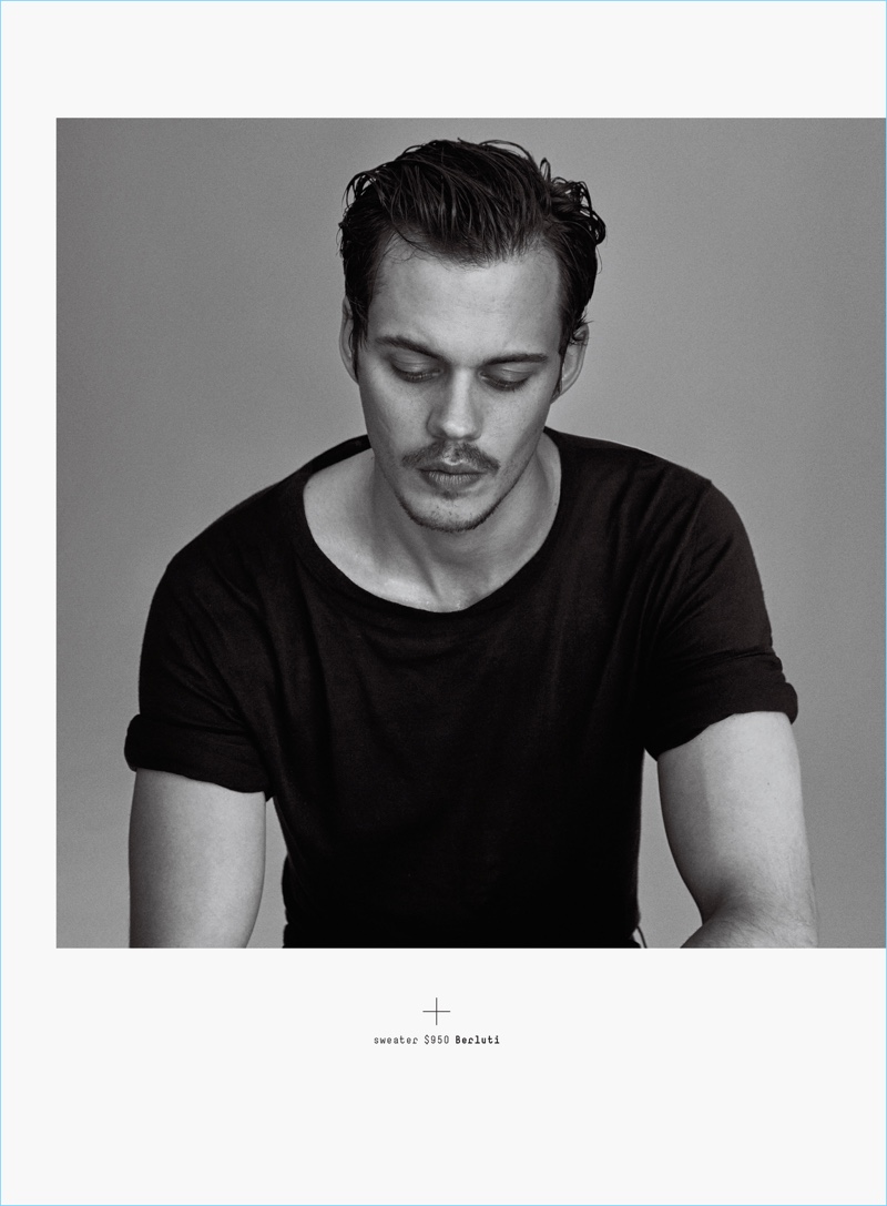 Contemplative, Bill Skarsgård sports a short-sleeve Berluti sweater.