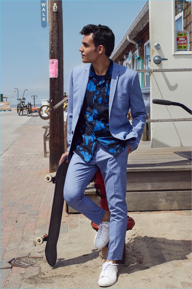 Connecting with H&M, Kilian Martin sports a skinny fit blazer, suit pants, resort shirt, and white sneakers.