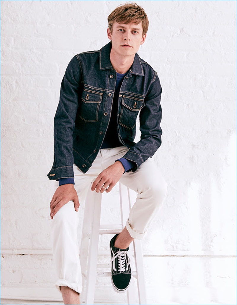 Janis Ancens sports Todd Snyder Japanese selvedge chino officer pants in white. He also wears a Todd Snyder Made in Los Angeles denim jacket with a sweatshirt from the designer's Champion collaboration. Vans Old Skool sneakers complete Janis' look.