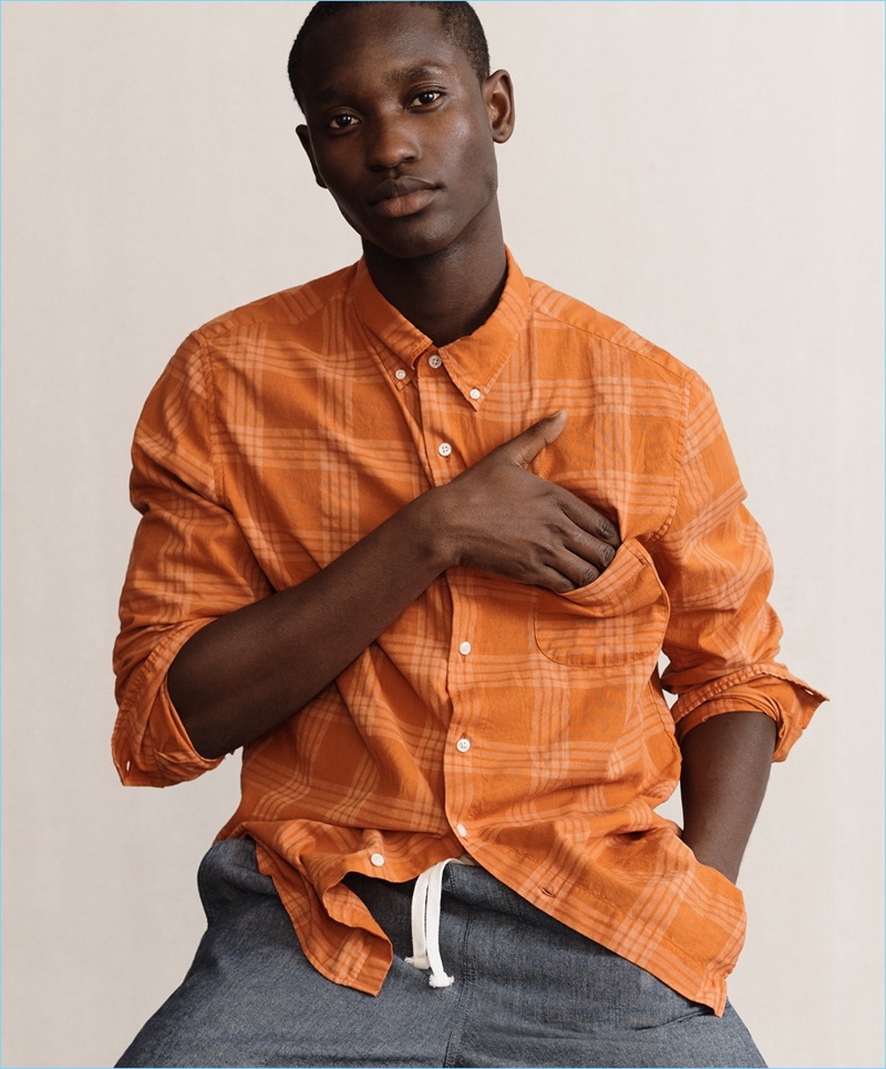 Charles Oduro wears a J.Crew overdyed plaid shirt and stretch dock shorts in chambray.