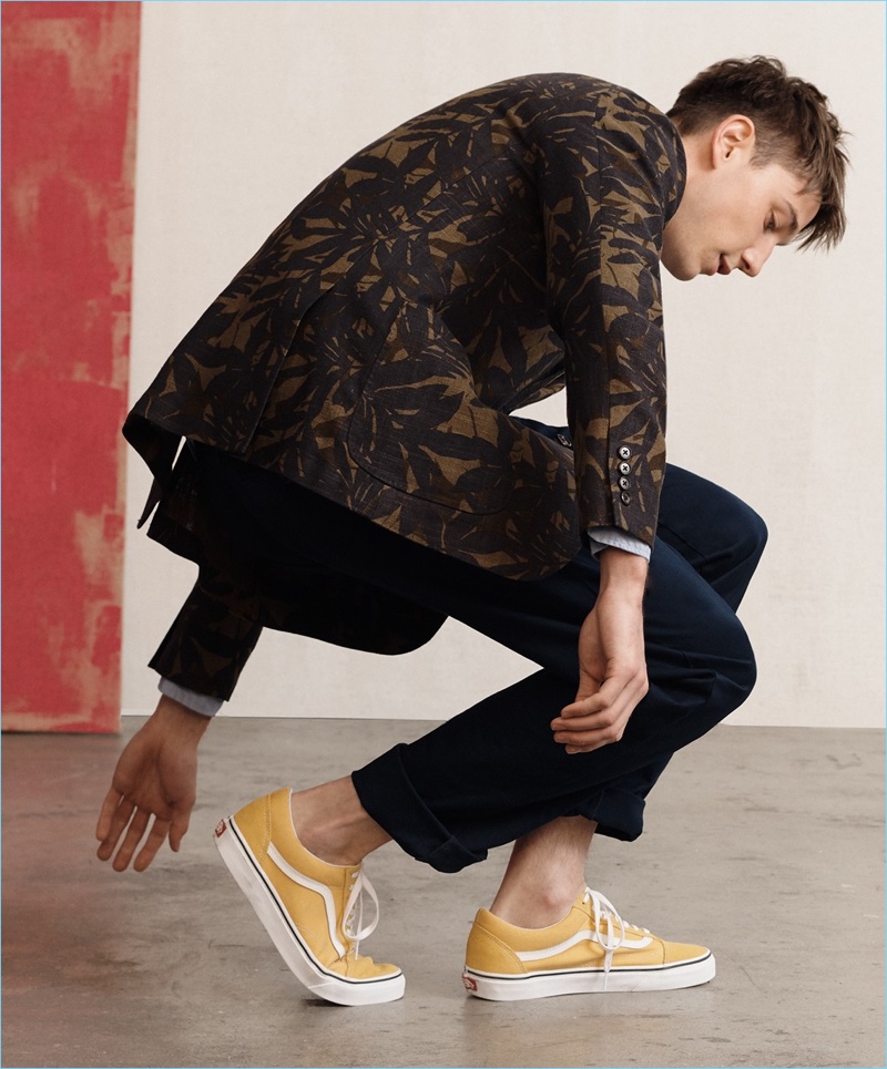 British model Harvey James wears a J.Crew palm leaf print Ludlow blazer, poplin shirt, chinos, and Vans sneakers.