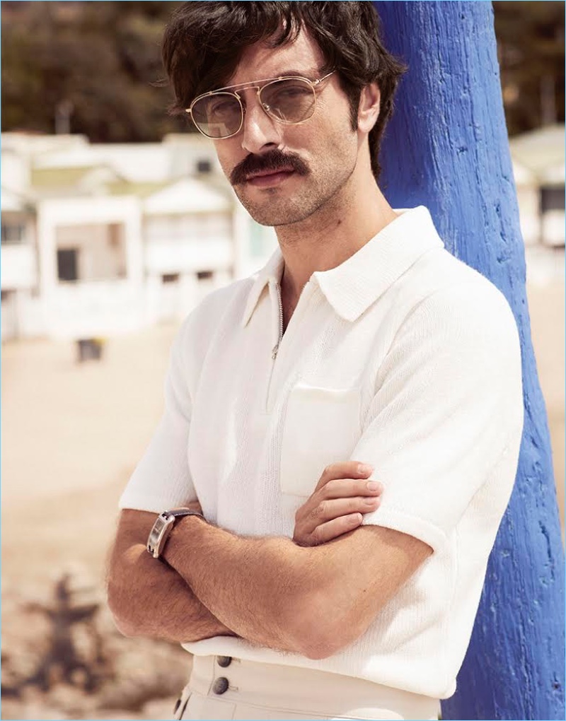 A summer vision, Javier Rey dons a Sandro polo, BOSS pants, a Hermès watch, and Lozza sunglasses.