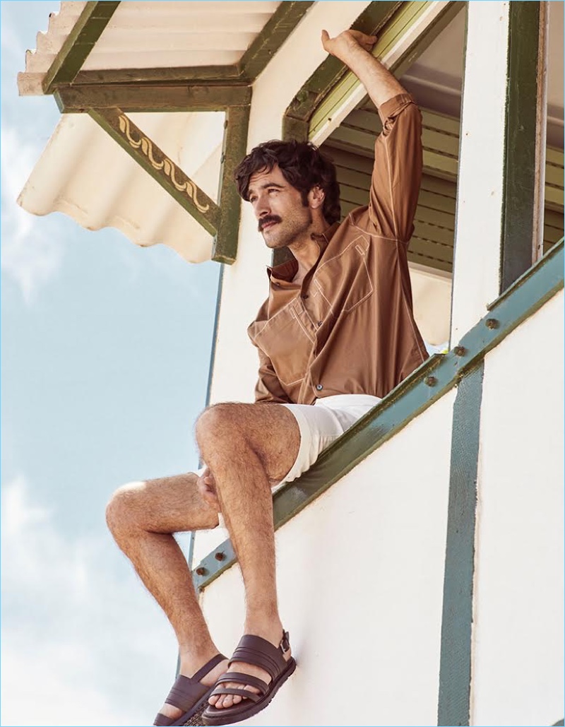 Javier Rey dons a shirt and sandals by Hermès with Bermuda shorts from Tomas Maier x UNIQLO.