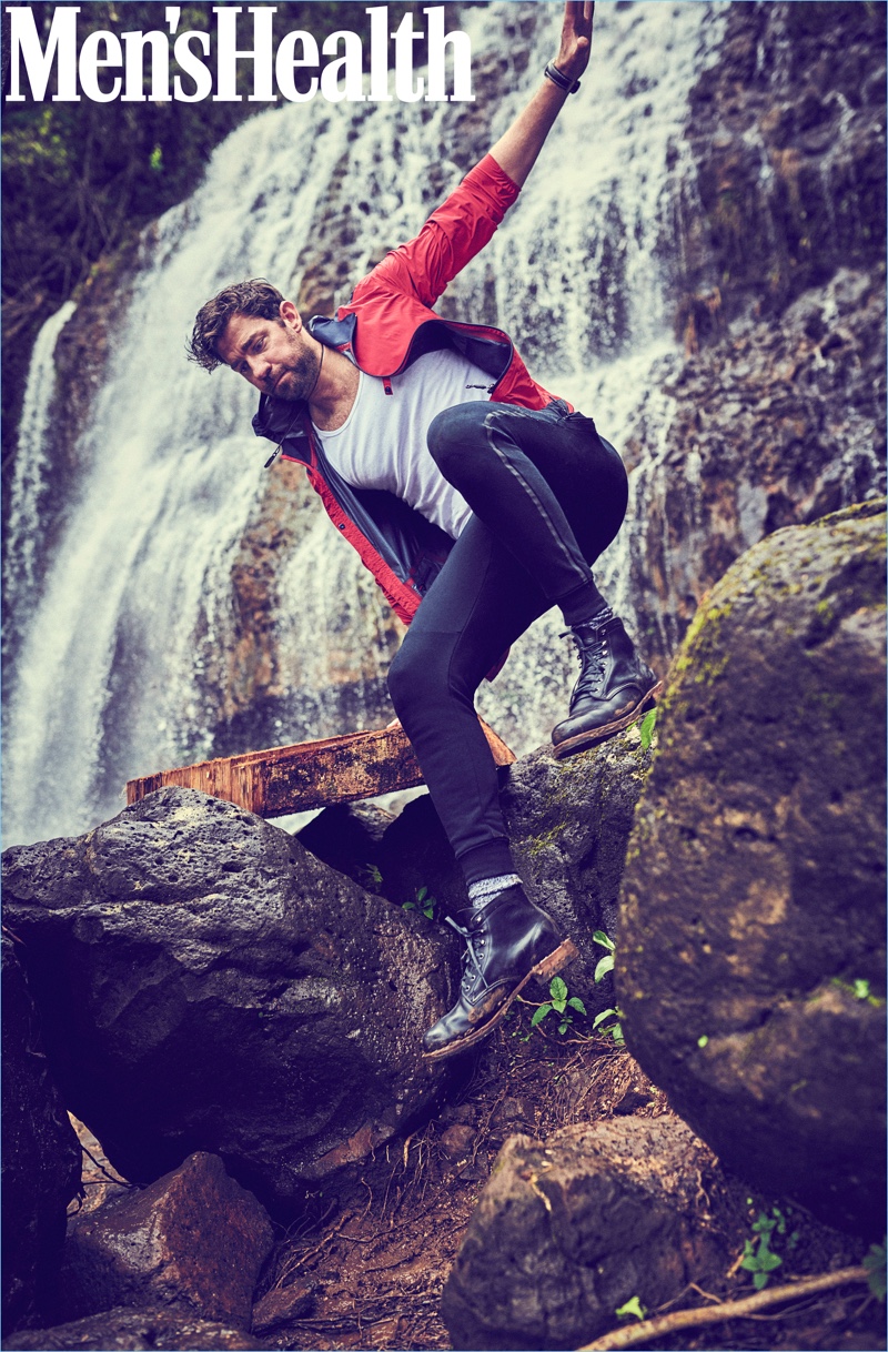 L'acteur John Krasinski porte un coupe-vent Z Zegna, un débardeur Calvin Klein, un jogger New Balance, des chaussettes American Trench, une montre Breitling et un collier David Yurman.