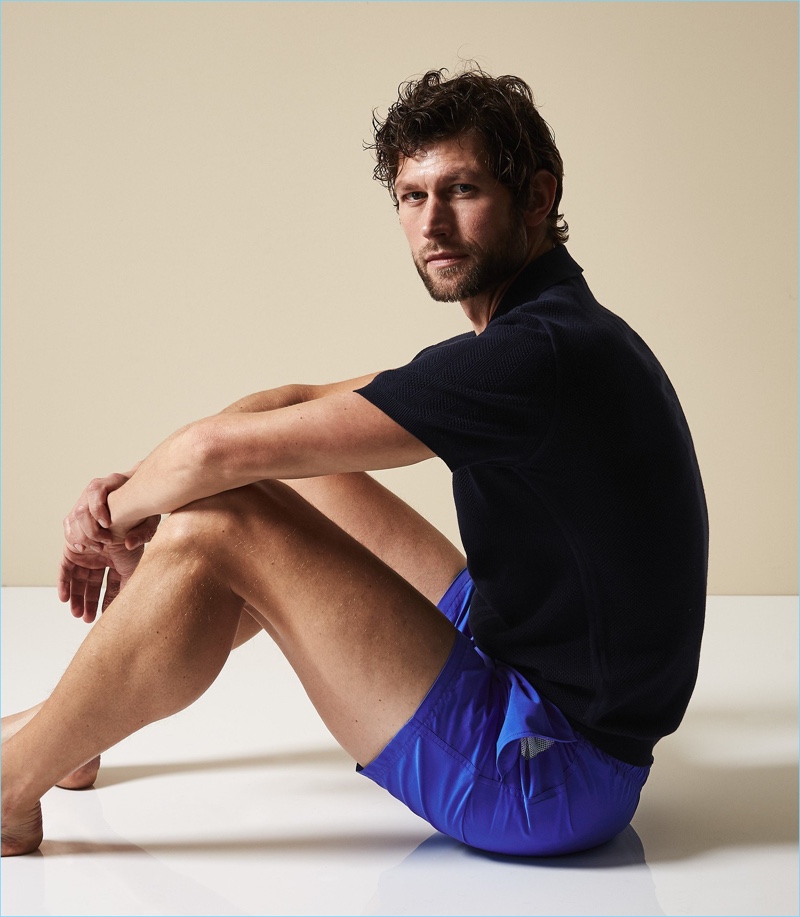 Jan Trojan wears Reiss' cobalt blue Sonar swim shorts with a black polo shirt.