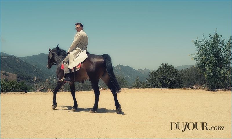 Riding a horse, Rupert Friend dons a Ralph Lauren coat and trousers with Christian Louboutin shoes. The Strange Angel actor wears Theirry Lasry sunglasses as well.