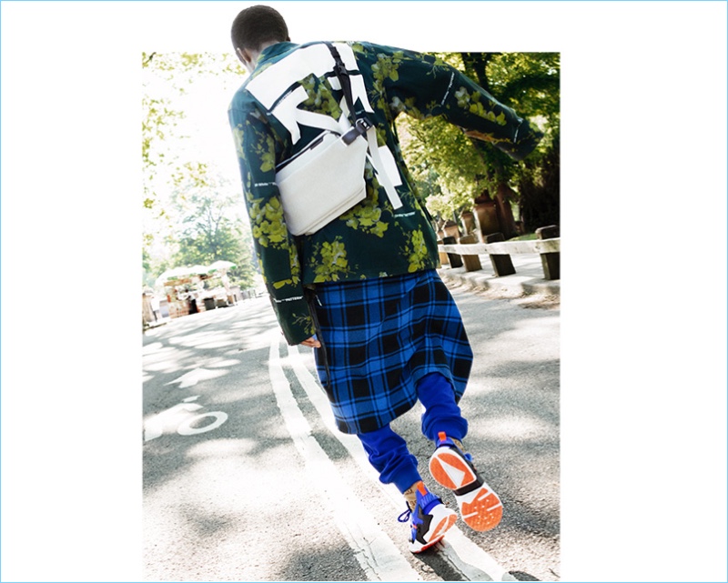 Going for a walk, Alton Mason wears jacket by Off-White, from Browns, T-shirt by McQ Alexander McQueen, from Vitkac, shirt (worn around waist) by Off-White, trousers by Versace, from Vitkac, bag by Côte&Ciel, from Giulio, socks by Gucci, and sneakers by Nike from Vitkac.