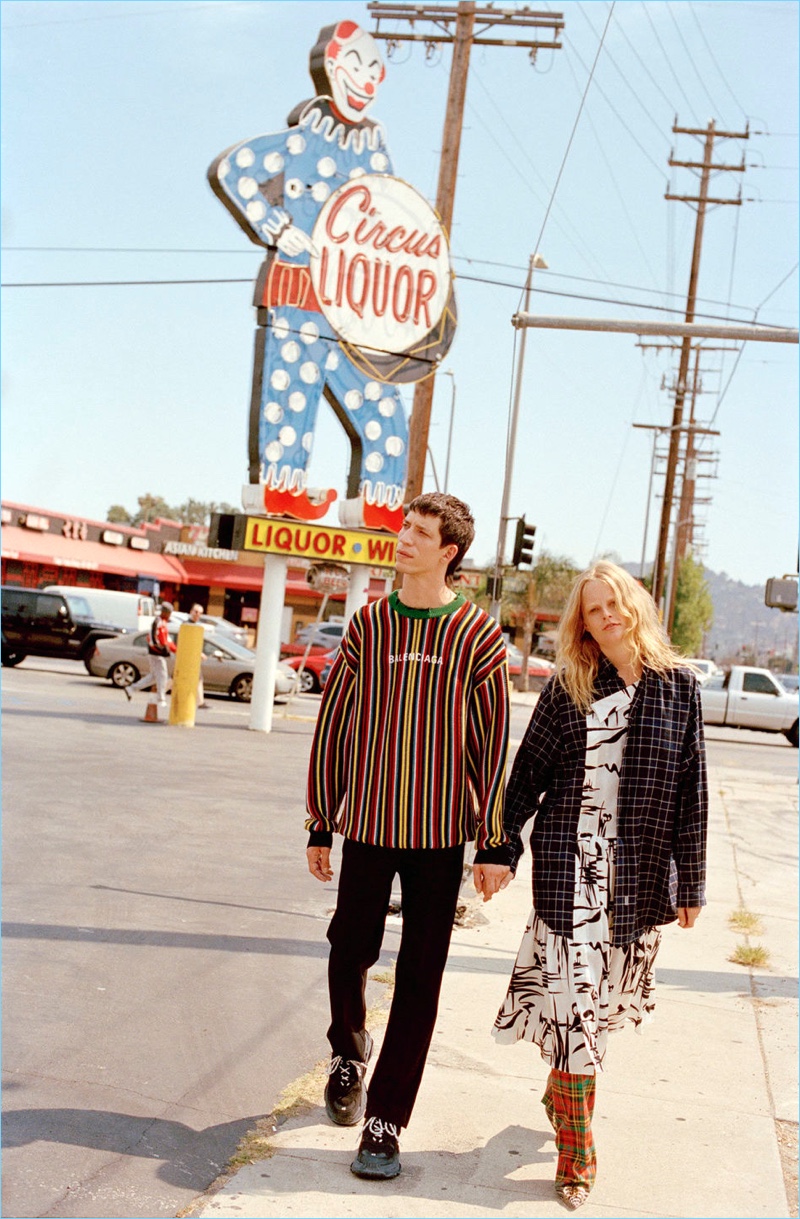 Running errands, John Swiatek and Hanne Gaby Odiele connect with Browns. On the move, John wears a sweater, trousers, and sneakers by Balenciaga.