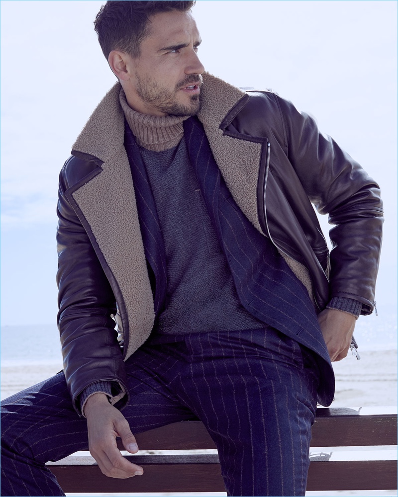 Suave, Arthur Kulkov layers in a Brunello Cucinelli pinstripe suit, shearling-lined moto jacket, and turtleneck sweater.