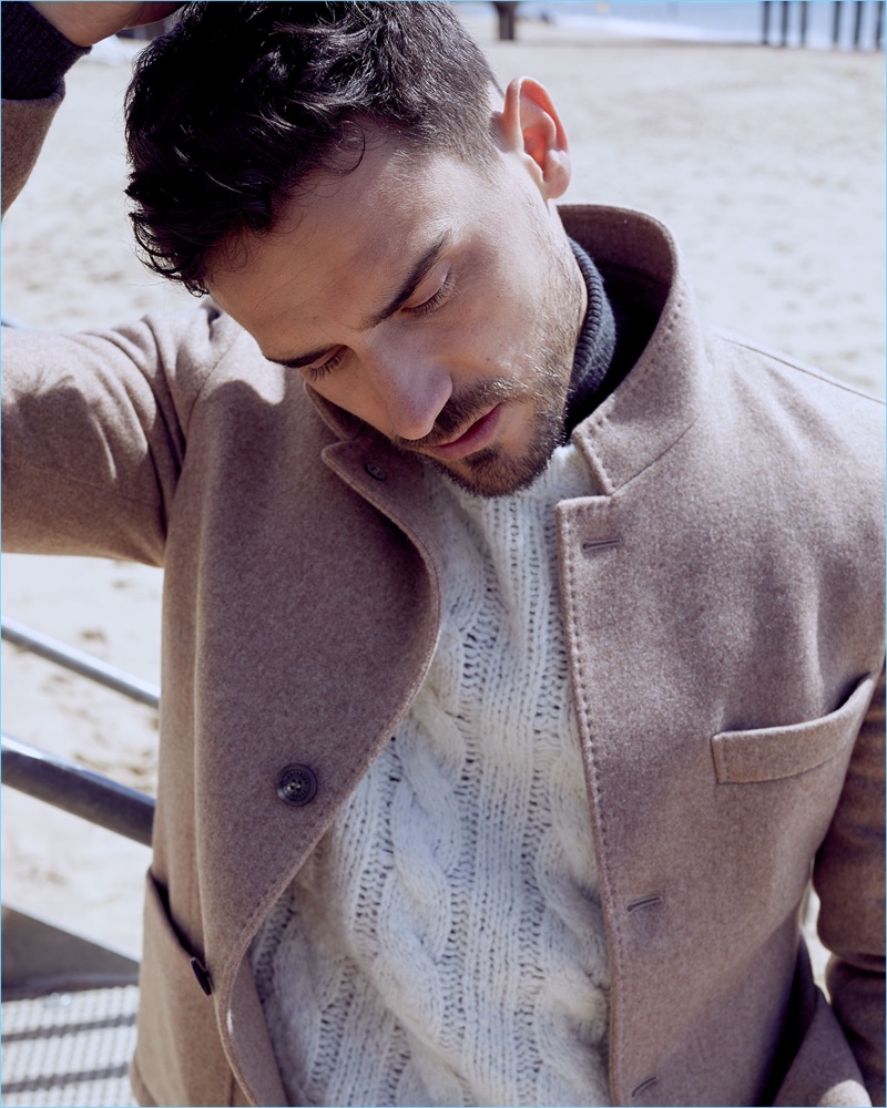 Model Arthur Kulkov sports a Brunello Cucinelli patch-pocket jacket, cable-knit sweater, and wool-cashmere turtleneck.