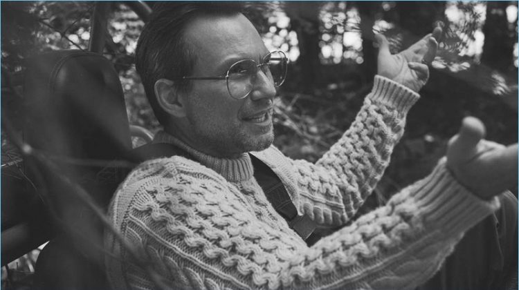 A smart vision, Christian Slater dons a Brioni cable-knit sweater and Gucci glasses.