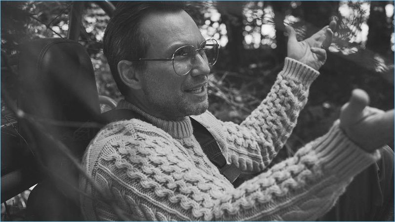 A smart vision, Christian Slater dons a Brioni cable-knit sweater and Gucci glasses.