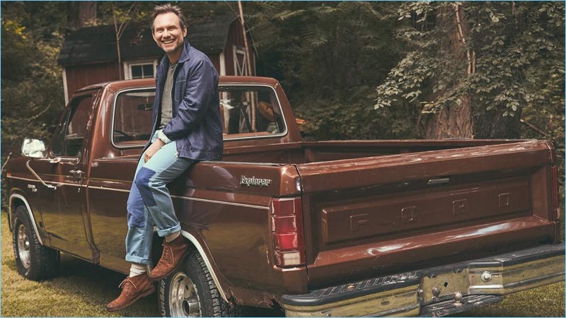 All smiles, Christian Slater wears an Oliver Spencer linen bomber jacket, Enlist t-shirt, and Officine Generale pants. He also sports Marsell Chukka boots and Beams Plus socks.