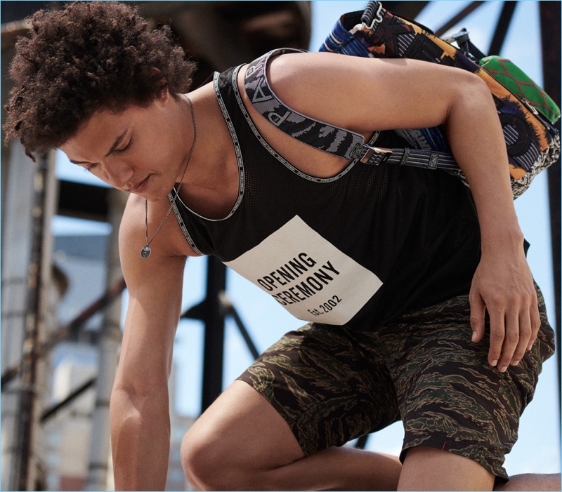 Tank: Gabriel Gomieri sports an Opening Ceremony tank, Carhartt WIP shorts, Miansai pendant necklace, and Kenzo backpack.