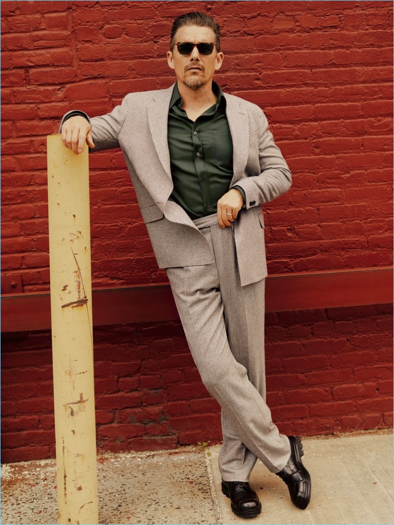 Stepping outside, Ethan Hawke wears a Billy Reid suit, Salvatore Ferragamo shirt, Giorgio Armani shoes, and Salt sunglasses.