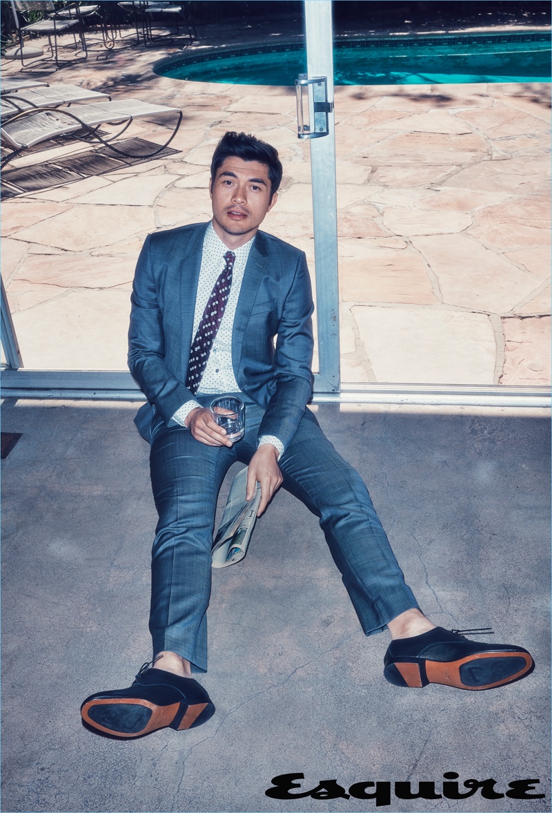 Connecting with Esquire, Henry Golding wears a shirt, suit, and shoes by Dolce & Gabbana with an Issey Miyake Men tie.