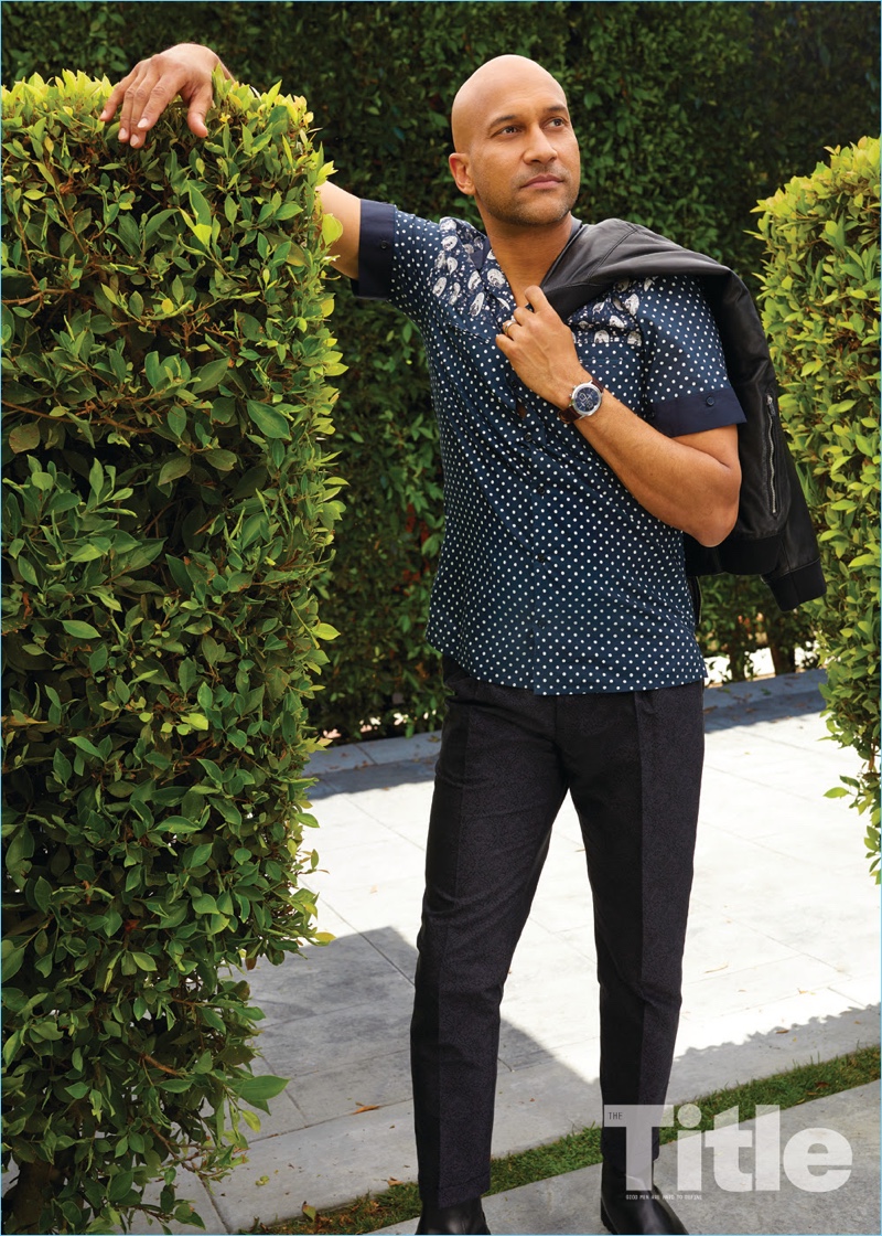 Sporting a Dolce & Gabbana shirt and pants, Keegan-Michael Key takes hold of an AllSaints jacket. 