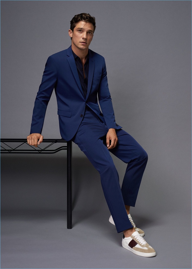 French model Alexis Petit goes for a sleek look in a navy suit and black shirt by Mango Man.