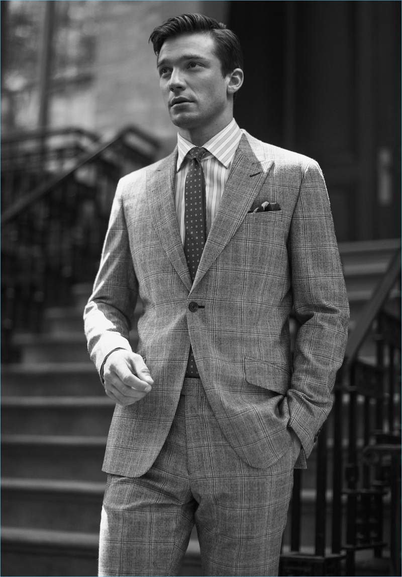 Strictly Business: Alexis Petit dons a grey suit, striped shirt, silk tie, and pocket square by Reiss.