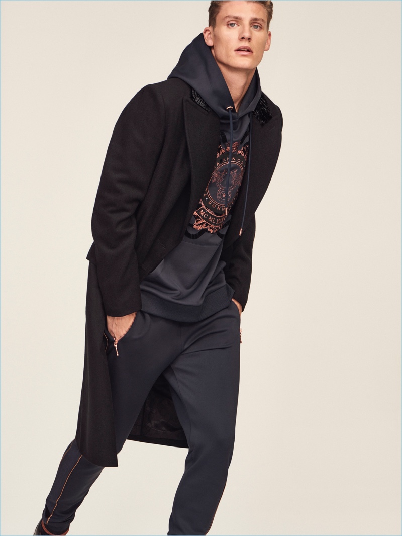 Mikkel Jensen dons a coat with a hoodie and joggers from River Island's RI30 collection.