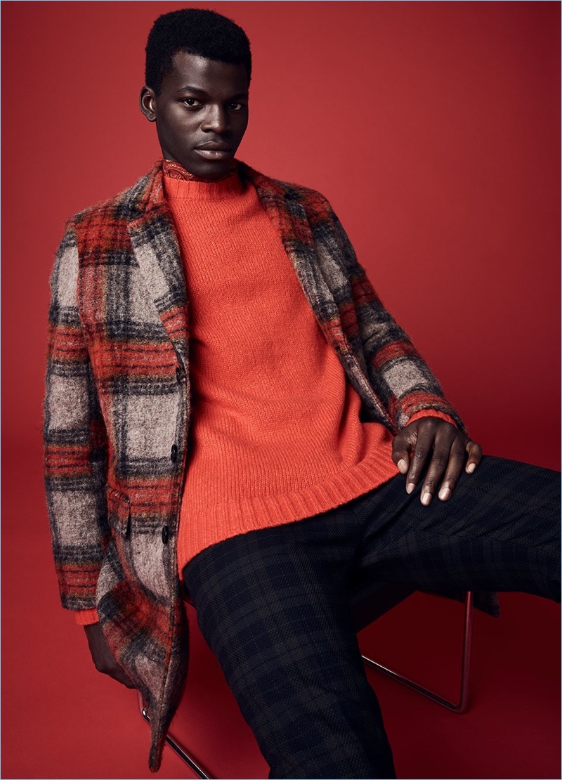 Embracing red, Evandro Laurens wears a Scotch & Soda sweater with a tartan coat and trousers.