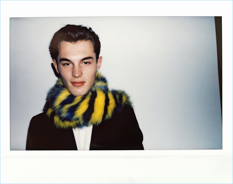 Sporting a scarf, Kit Butler appears in a behind the scenes polaroid for Tiger of Sweden.