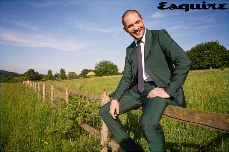 All smiles, Tom Hardy wears shirt and suit by Gucci with a vintage tie.