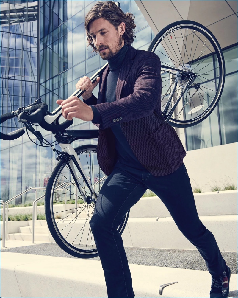 On the move, Wouter Peelen wears a red travel blazer, 5-pocket pants, and a turtleneck sweater by Canali.